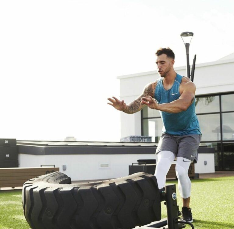 A man doing a push up on a tire.