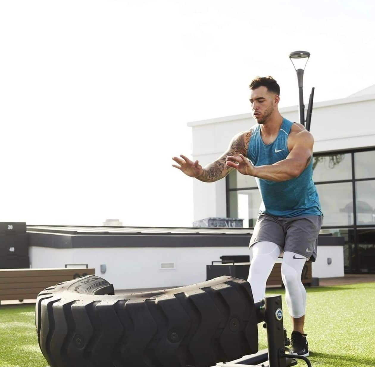 A man doing a push up on a tire.