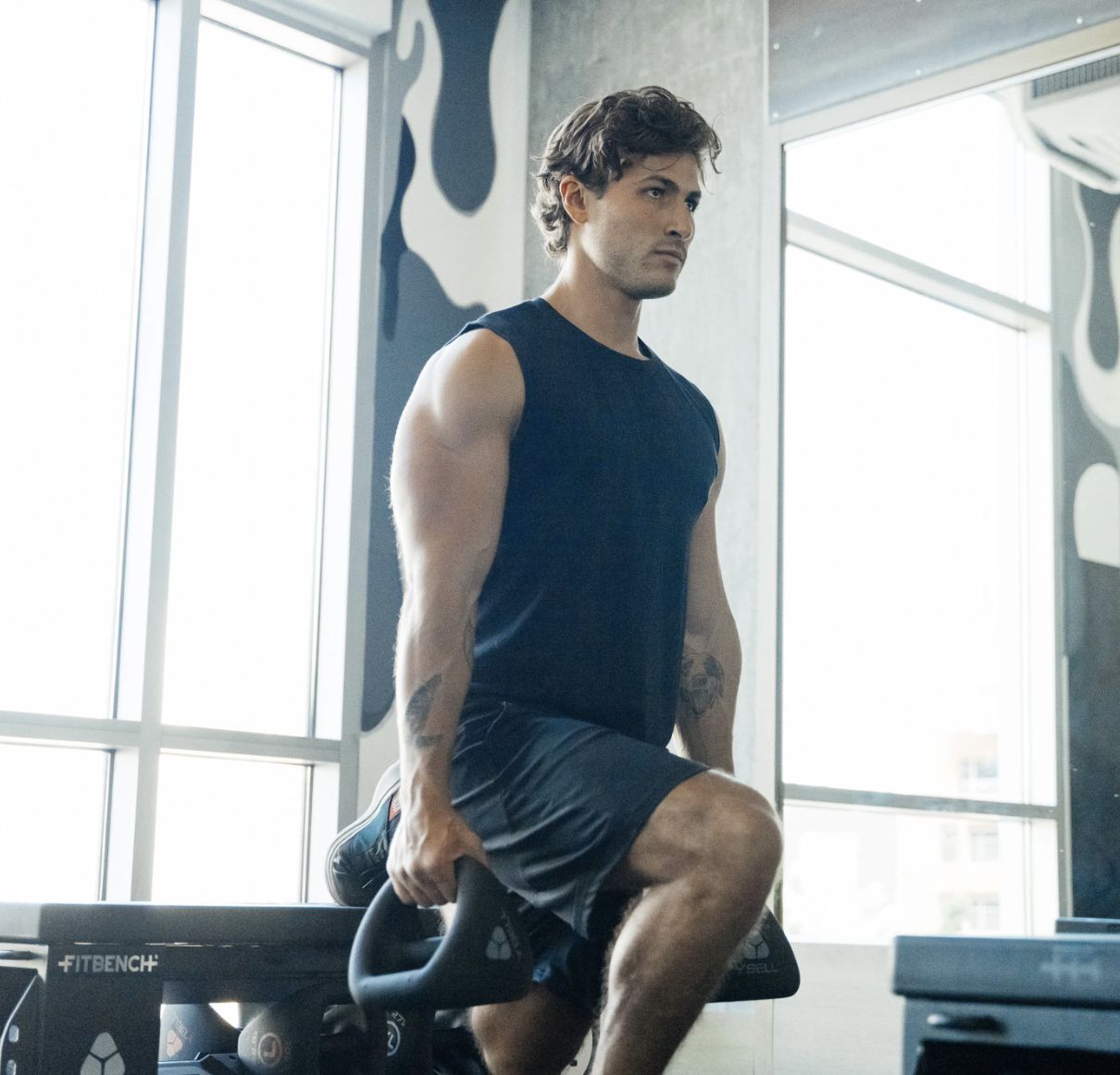 A man doing squats in a gym.