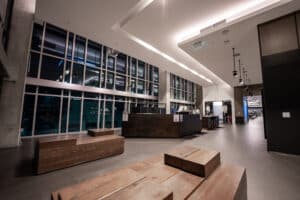 A lobby with wooden benches and large windows.