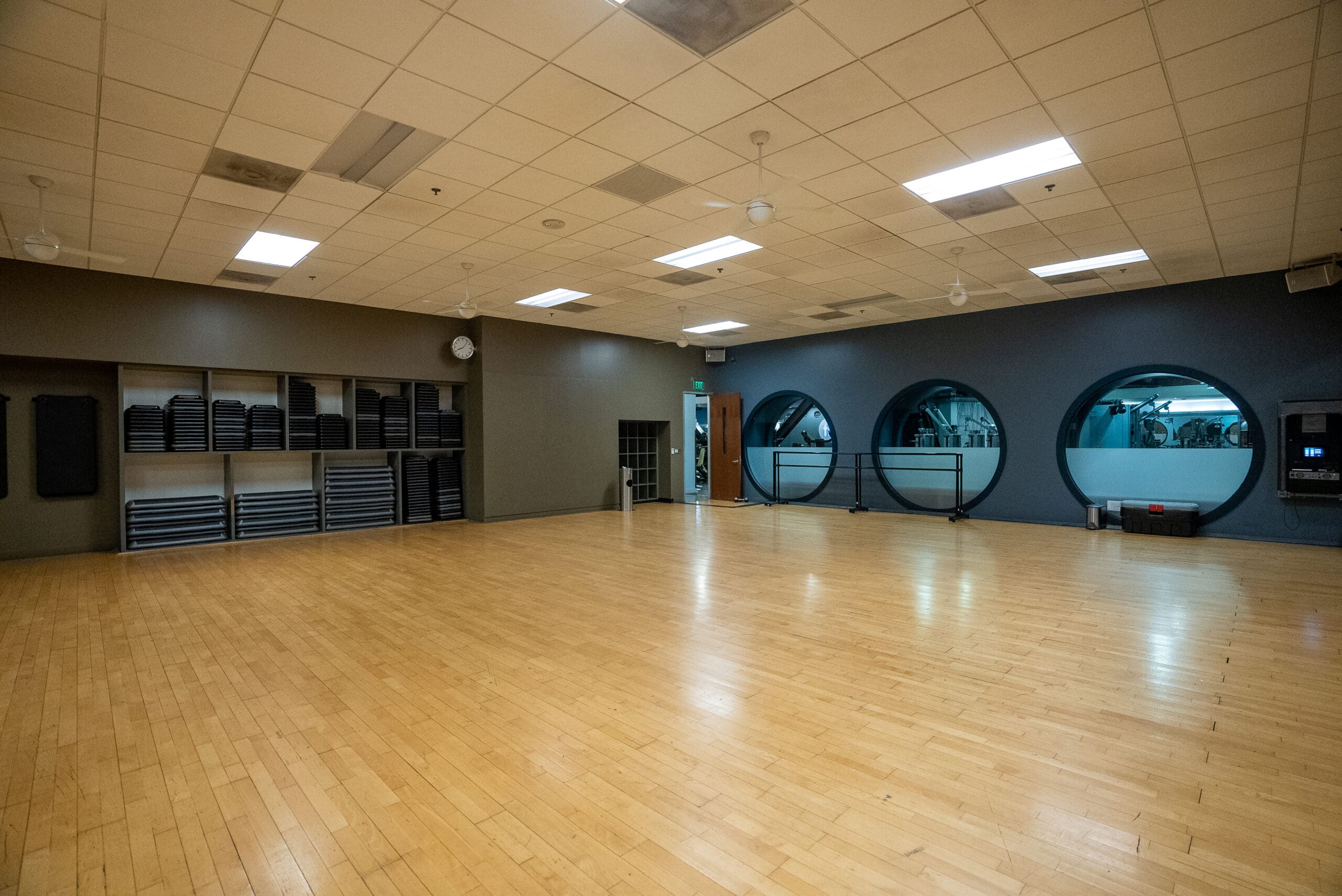 An empty dance studio with wooden floors.